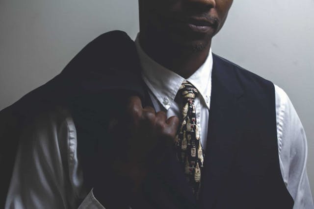 a black man in a collared shirt with a tie