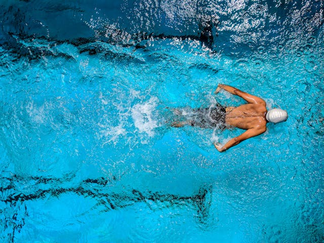 a man in a swim cap swimming across a pool