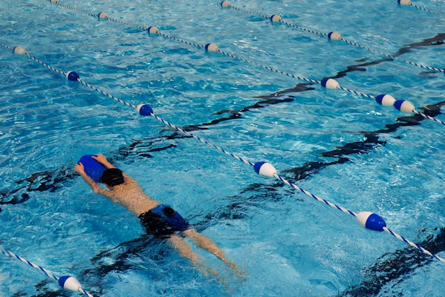 a man with a kickboard swimming in a pool