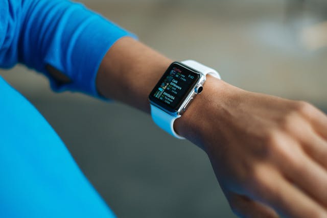 an individual wearing a smart watch with the screen illuminated