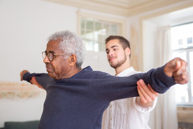 a young man helping an older man stretch