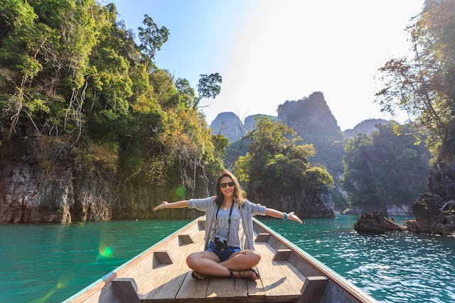 a woman sitting in a boat in a tropical destination