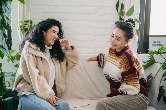 two women chatting on a couch