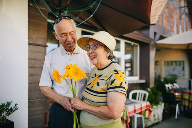 a grandma and grandpa holding flowers