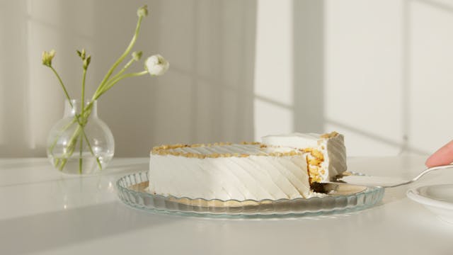 a white cake on a plate with a slice being lifted out of it