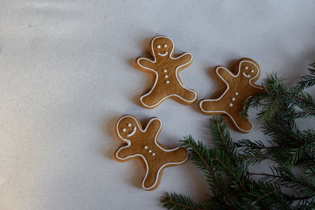 three gingerbread men by a tree branch