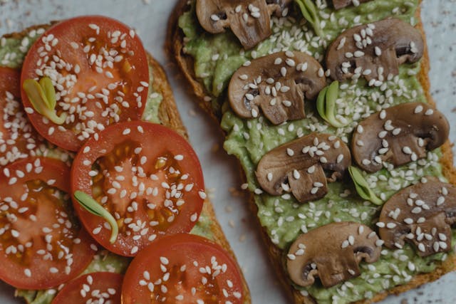 avocado toast one slice with tomatoes the other with mushrooms