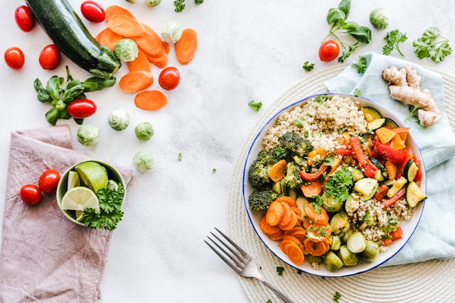 a bowl of salad on a table cloth with vegetables