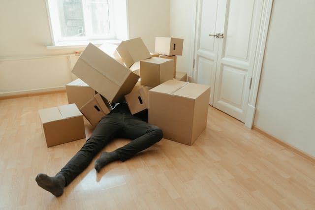 a pair of legs sticking out from a pile of boxes
